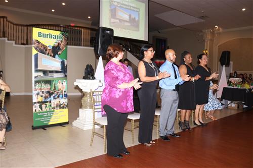 Administrators applaud as the award recipients approach the podium 